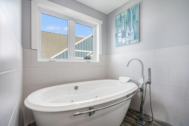 bathroom with tile walls and a tub