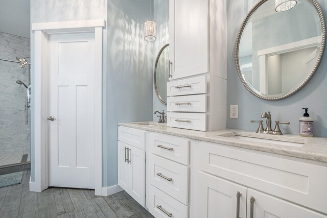 bathroom featuring hardwood / wood-style floors, vanity, and tiled shower