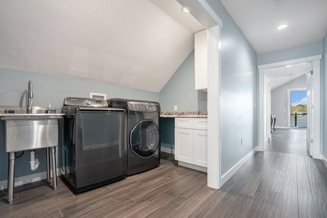 clothes washing area featuring cabinets, dark hardwood / wood-style flooring, washing machine and dryer, and sink