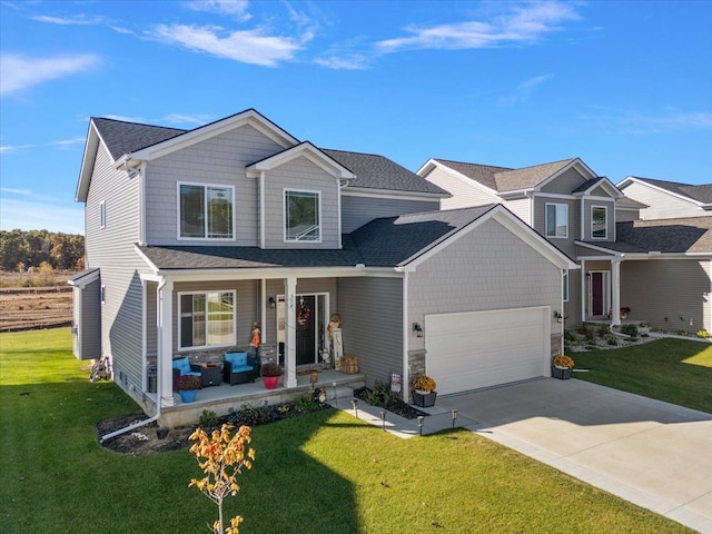 view of front of home featuring covered porch, a front yard, and a garage