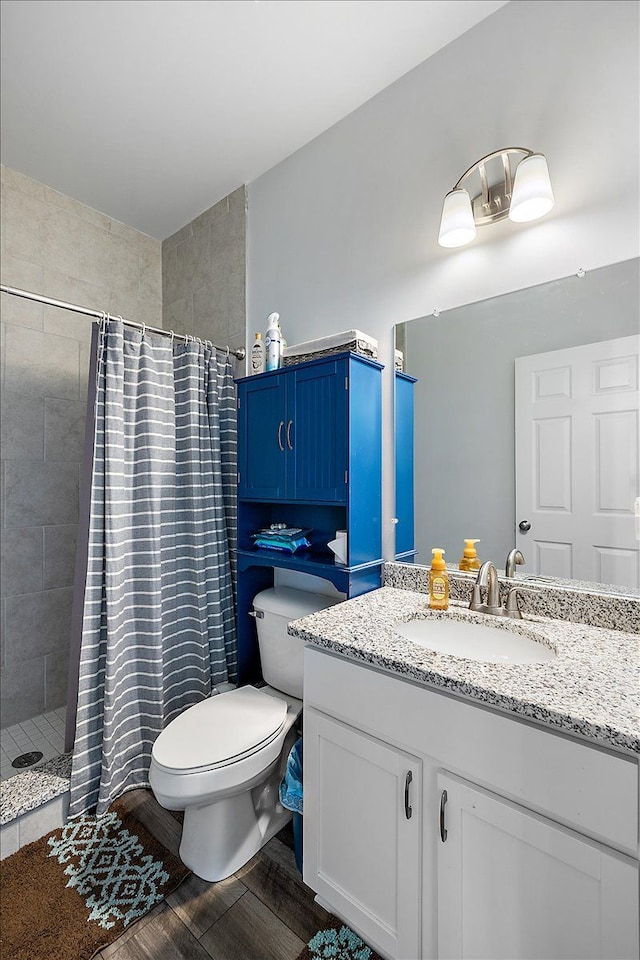 bathroom featuring vanity, curtained shower, toilet, and wood-type flooring