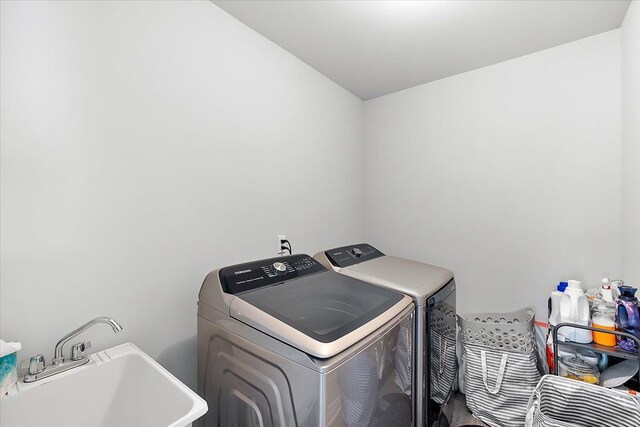 clothes washing area with washer and dryer and sink