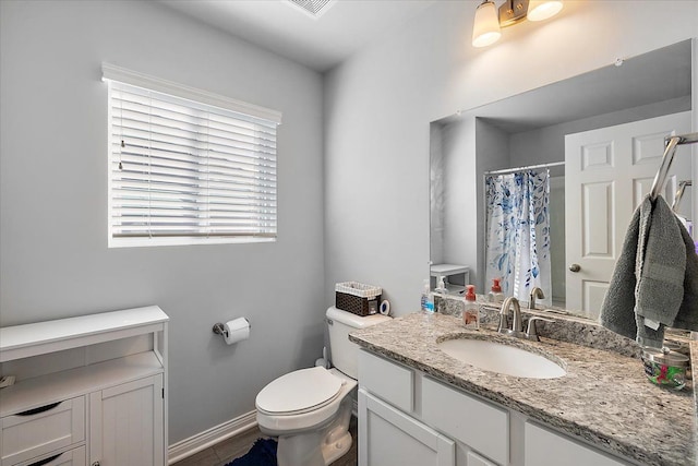 bathroom featuring a shower with shower curtain, vanity, and toilet