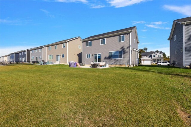 rear view of property featuring a patio and a lawn