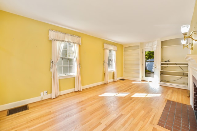 spare room with plenty of natural light and hardwood / wood-style floors