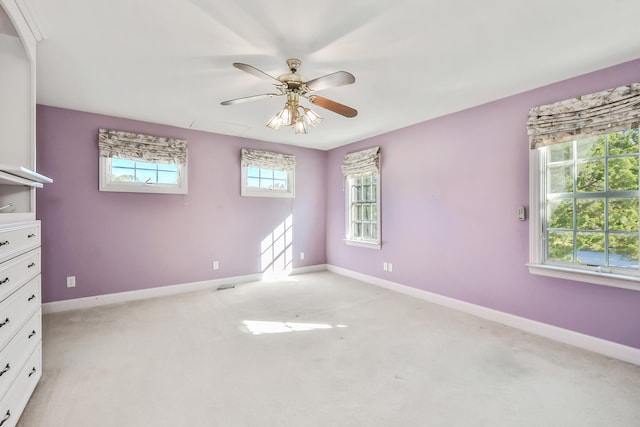 empty room with ceiling fan and light colored carpet