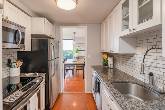 kitchen featuring white cabinets, sink, stainless steel appliances, and light hardwood / wood-style flooring