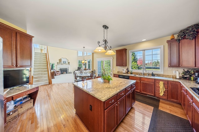 kitchen with light hardwood / wood-style flooring, a kitchen island, hanging light fixtures, and sink