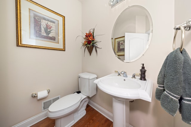 bathroom featuring wood-type flooring and toilet