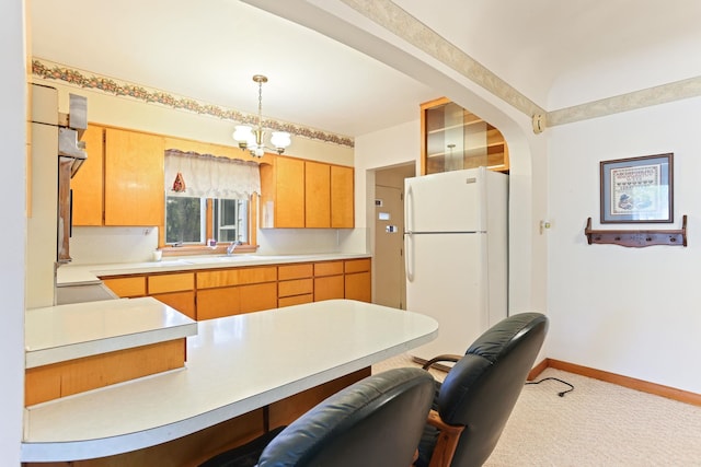 kitchen with sink, an inviting chandelier, white fridge, decorative light fixtures, and carpet