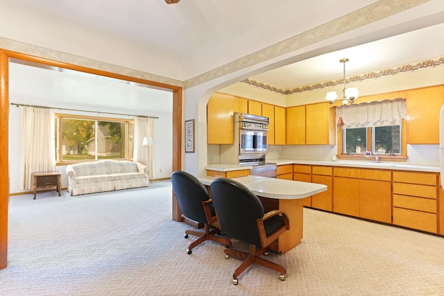 kitchen with light carpet, an inviting chandelier, sink, hanging light fixtures, and appliances with stainless steel finishes