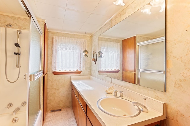 bathroom featuring vanity and bath / shower combo with glass door