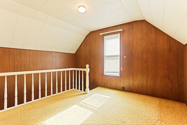 additional living space featuring carpet, wooden walls, and vaulted ceiling