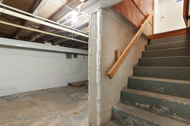 stairs featuring concrete flooring