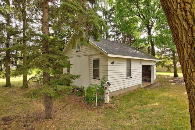 view of side of property with a lawn and an outbuilding