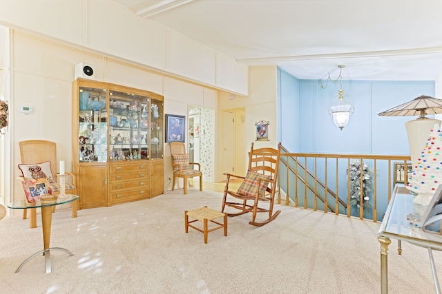 sitting room with beamed ceiling and light colored carpet