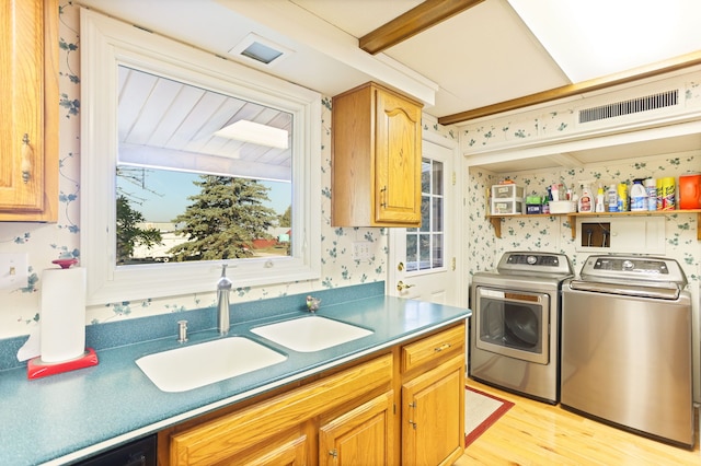 washroom featuring independent washer and dryer, light hardwood / wood-style flooring, and sink