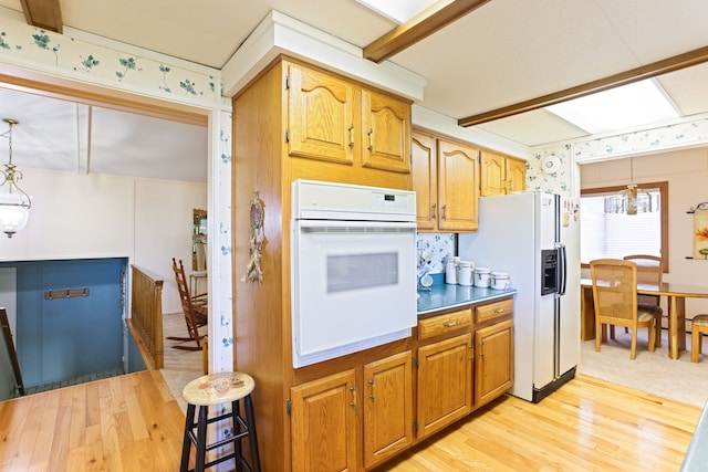 kitchen featuring a chandelier, white appliances, decorative light fixtures, and light hardwood / wood-style flooring