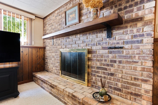 carpeted living room featuring wood walls and ornamental molding