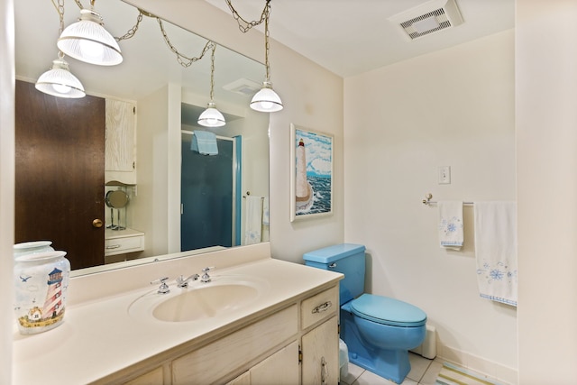 bathroom with toilet, vanity, and tile patterned floors