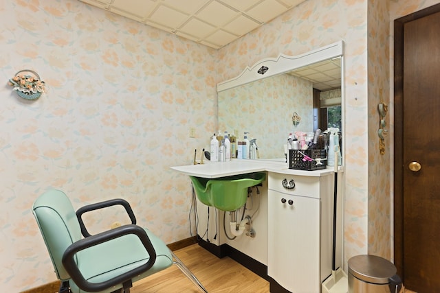 bathroom with a paneled ceiling and wood-type flooring