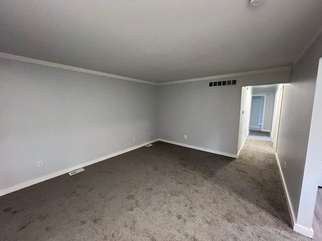 unfurnished room featuring dark colored carpet and ornamental molding