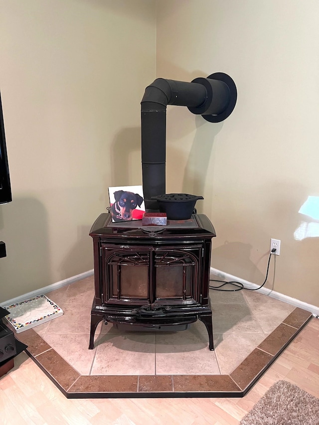 interior details with hardwood / wood-style flooring and a wood stove