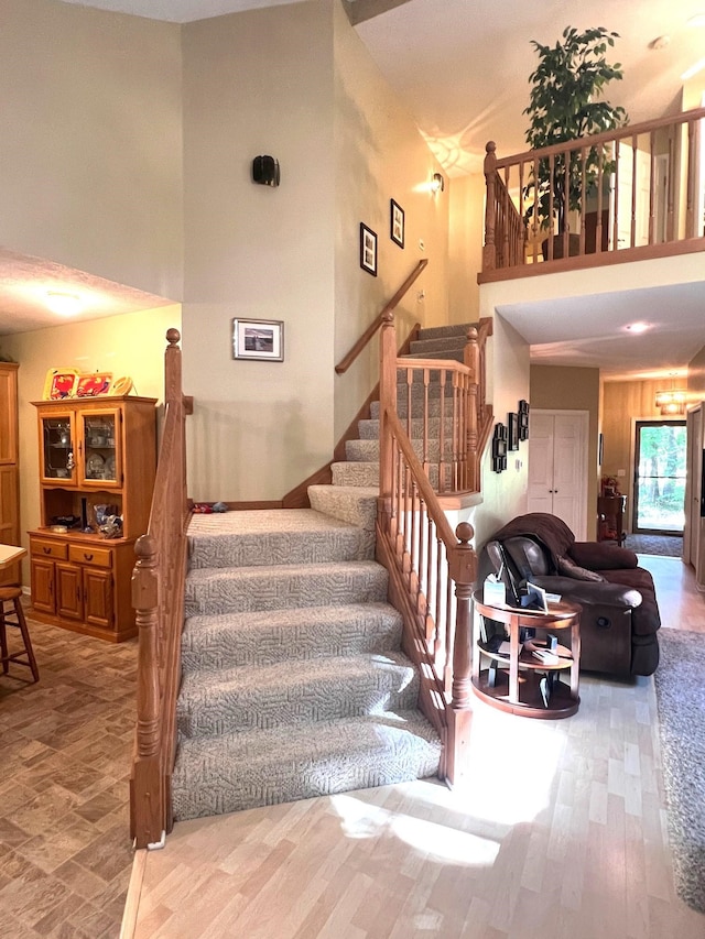 stairway with a high ceiling and hardwood / wood-style flooring