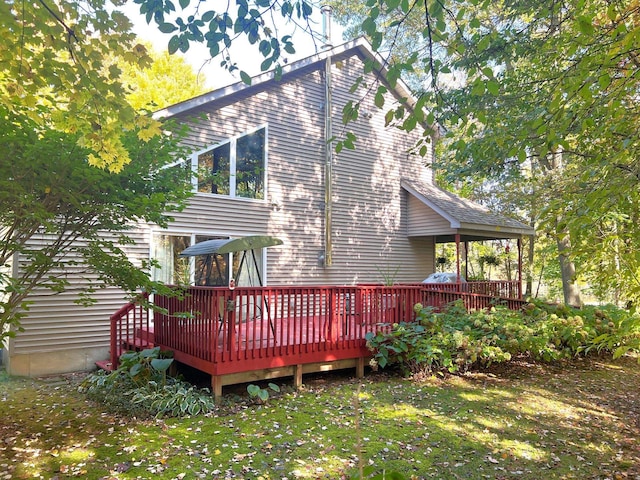 back of house featuring a lawn and a wooden deck