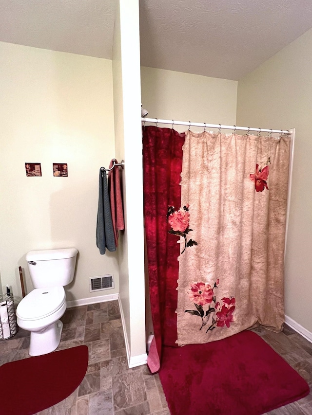 bathroom featuring toilet and walk in shower