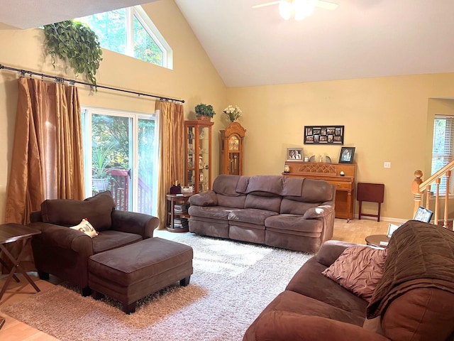 living room with ceiling fan, light wood-type flooring, and high vaulted ceiling