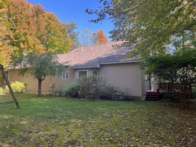 rear view of property featuring a lawn and a deck