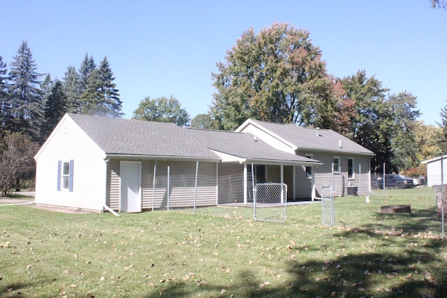 rear view of house featuring a yard