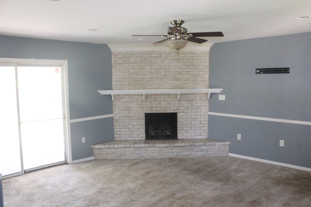 unfurnished living room featuring carpet flooring, ceiling fan, and a brick fireplace