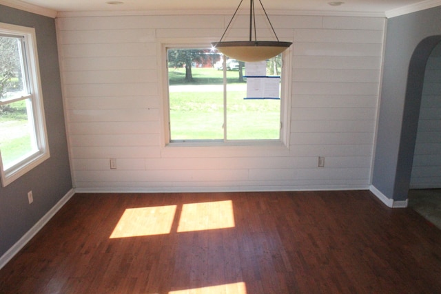 unfurnished dining area featuring dark hardwood / wood-style flooring and crown molding