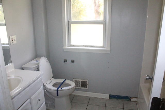 bathroom with tile patterned floors, plenty of natural light, vanity, and toilet