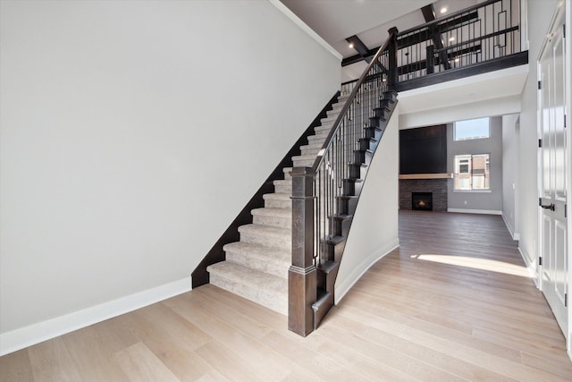 staircase with a towering ceiling and wood-type flooring