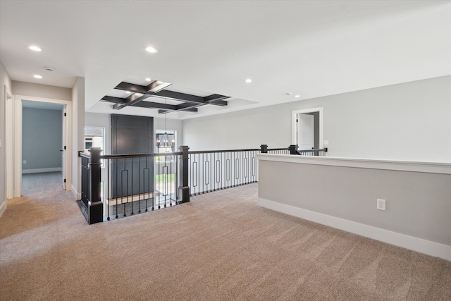 hall with beam ceiling, light colored carpet, coffered ceiling, and a chandelier