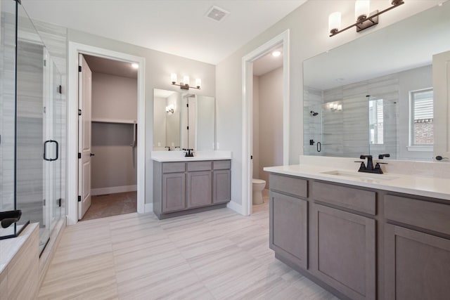 bathroom featuring a shower with door, tile patterned floors, vanity, and toilet