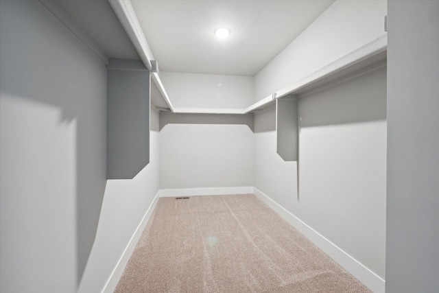 walk in closet featuring light colored carpet