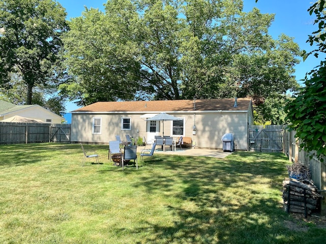 back of property with a yard and a patio