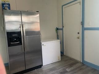 kitchen featuring white cabinets, stainless steel refrigerator with ice dispenser, and hardwood / wood-style flooring