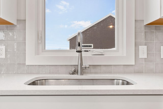 details featuring white cabinets and sink