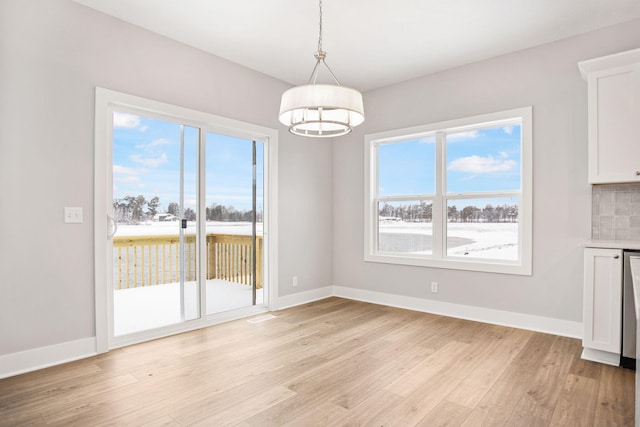 unfurnished dining area featuring plenty of natural light and light wood-type flooring