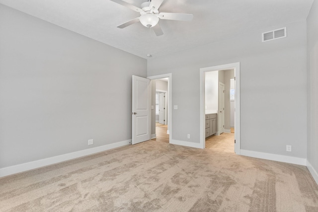 unfurnished bedroom with ceiling fan, light carpet, and ensuite bath