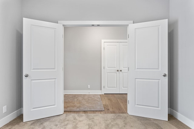 unfurnished bedroom with light carpet and a closet