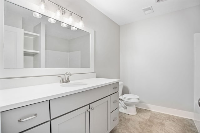 bathroom featuring vanity, toilet, and walk in shower