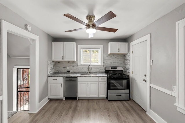 kitchen with white cabinets, stainless steel appliances, light hardwood / wood-style flooring, and sink