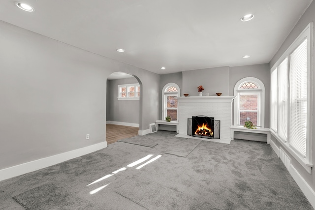 unfurnished living room featuring a fireplace and carpet