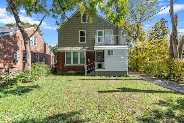 back of house with a lawn and a balcony